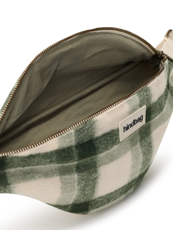 A close-up of a green and cream plaid pouch bag shown open, displaying its interior lining and a white brand label that reads 'hindbag'.