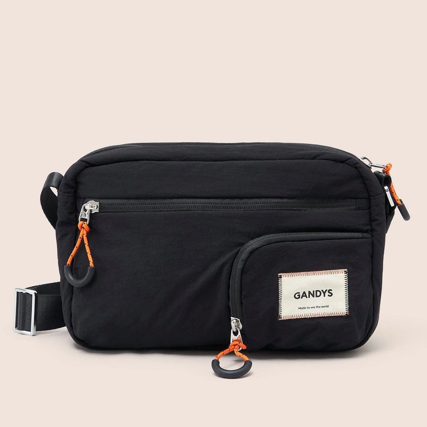 Black waist bag with orange zippers and 'GANDYS' brand label on a beige background