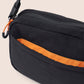 Black bag with orange interior lining on a beige background