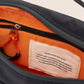 Close-up of a bag with a label on an orange and black background