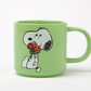 pastel green mug with snoopy sat holding a colourful bunch of flowers 