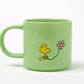 pastel Green mug with snoopy cartoon character holding a pink flower on a white background
