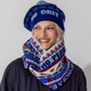 Person wearing a blue knit hat and blue, red and beige knitted snood 'No Grit No Pearl, Woman Power' text and symbols 
