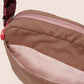 Close-up of a brown bag with a red zipper on a beige background