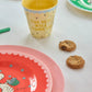 Colorful plates and a cup on a white surface with cookies.