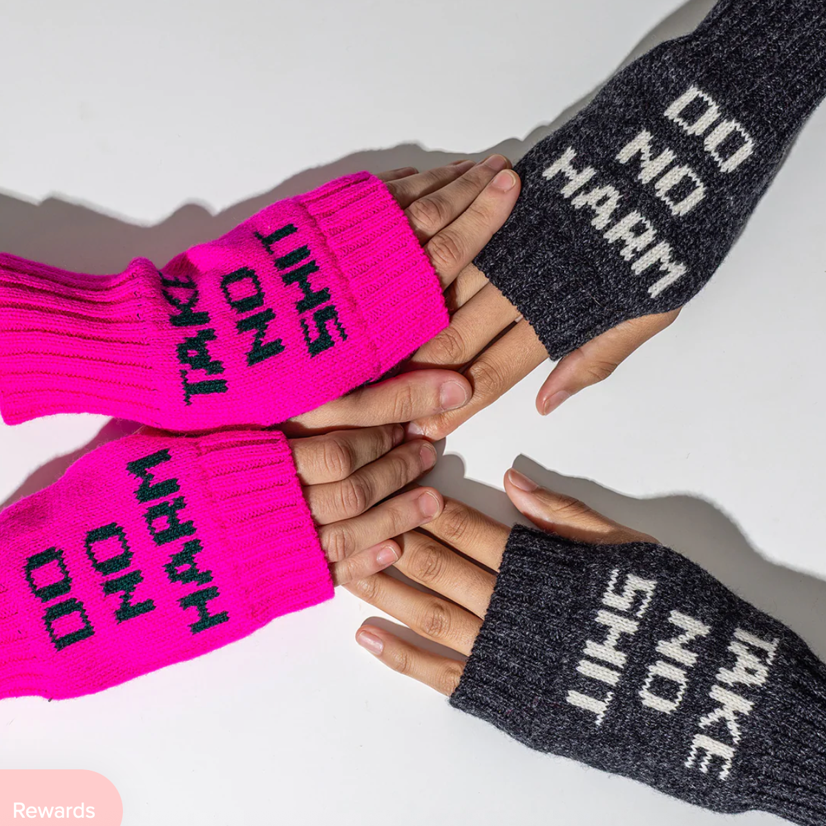 two people wearing hot pink and gray fingerless gloves with black text on 'DO NO HARM TAKE NO SHIT' on  a white background