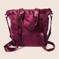Maroon handbag with chain details on a beige background