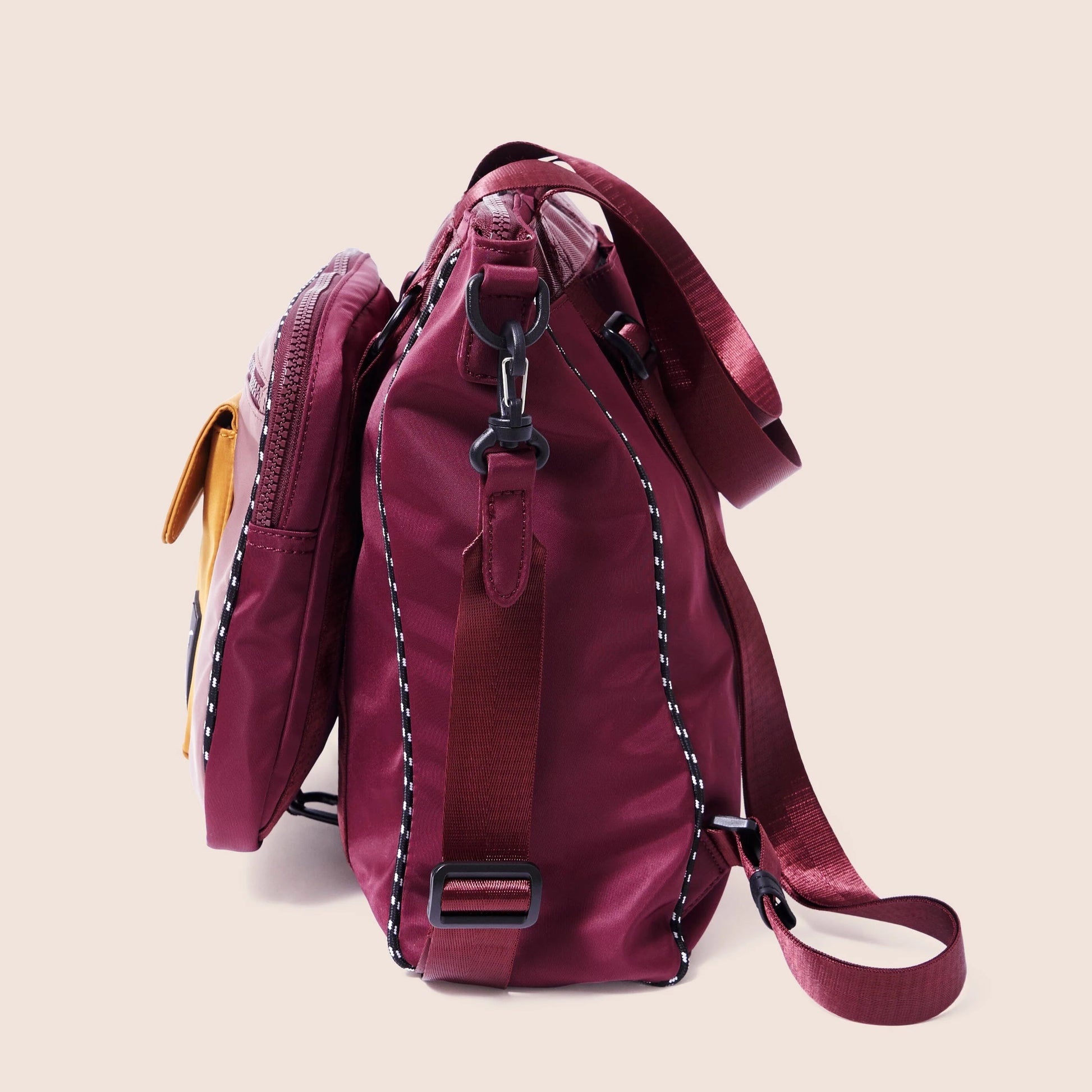 Maroon backpack with a strap on a beige background