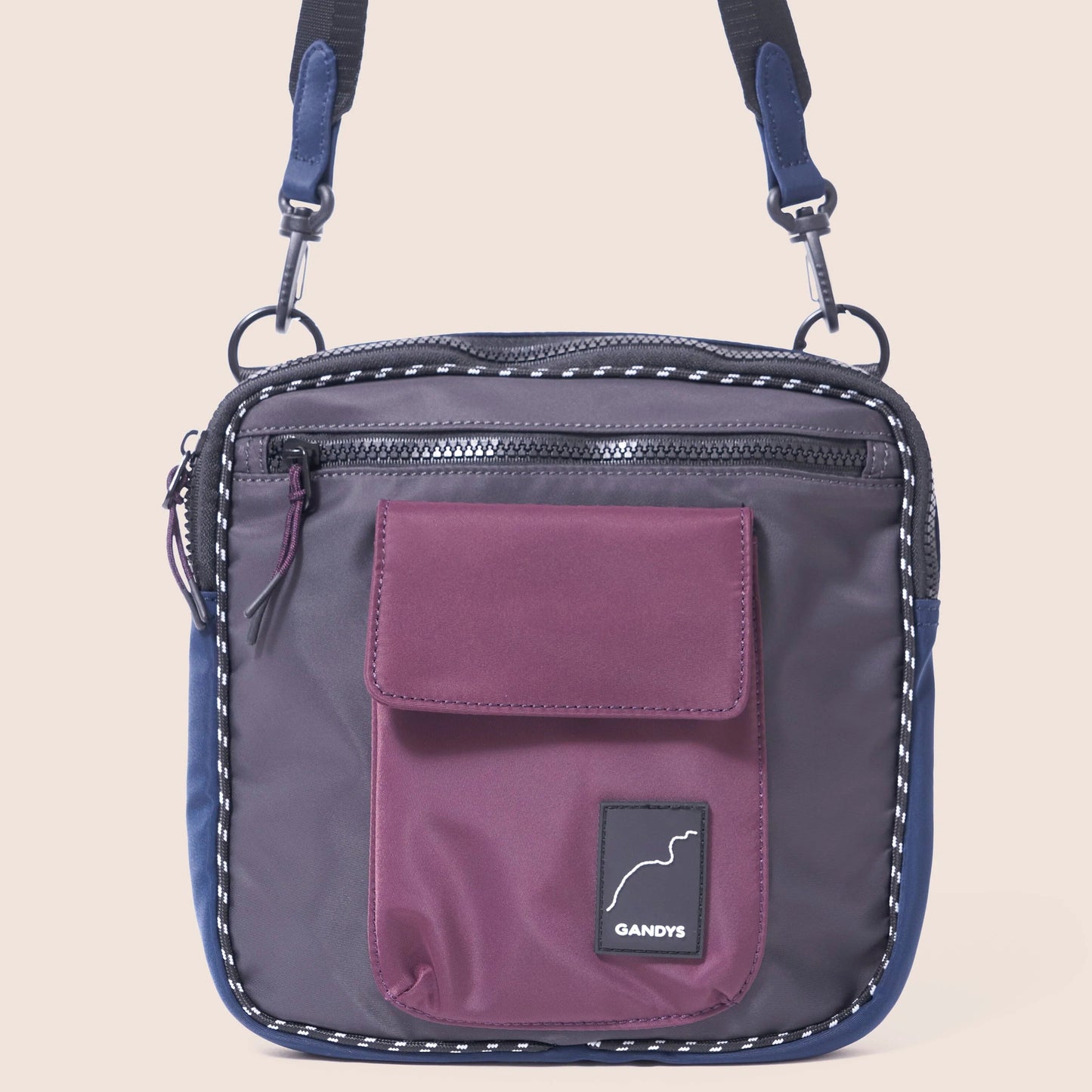 Purple crossbody bag with a visible brand logo on a beige background