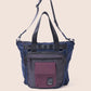 Blue and purple handbag with a visible brand logo on a beige background