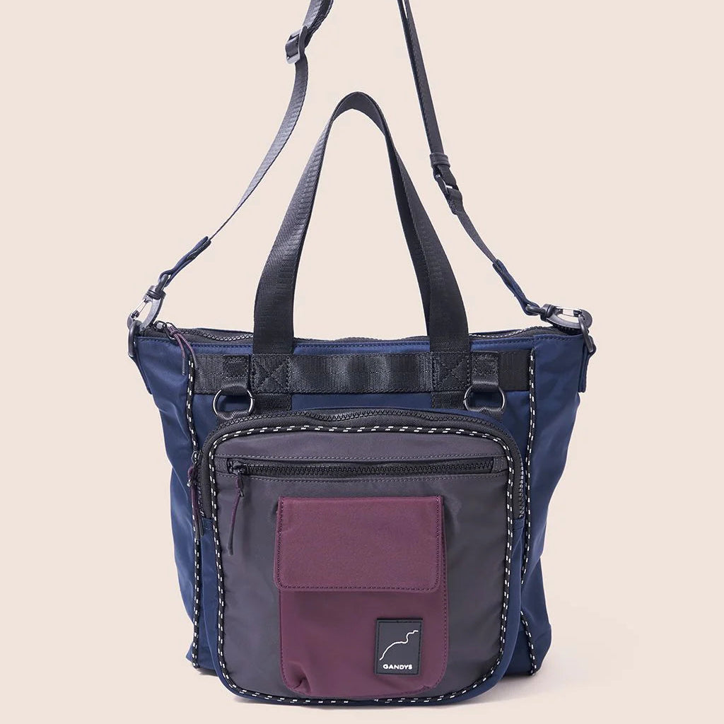 Blue and purple handbag with a visible brand logo on a beige background