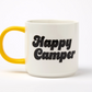 white Mug with 'Happy Camper' in black text and yellow handle on a white background