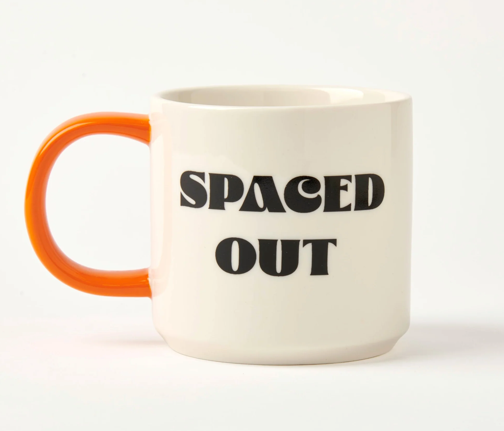 white mug with orange handle and black 'SPACED OUT' text on a white background