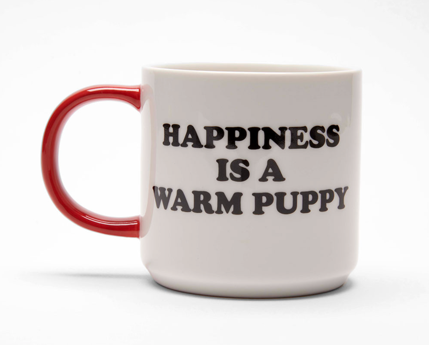 White mug with red handle and black 'Happiness is a warm puppy' text on a white background