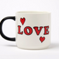 White mug with black handle featuring red hearts and the word 'LOVE' on a white background
