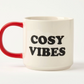 white mug with red handle and  'Cosy Vibes' black text on a white background