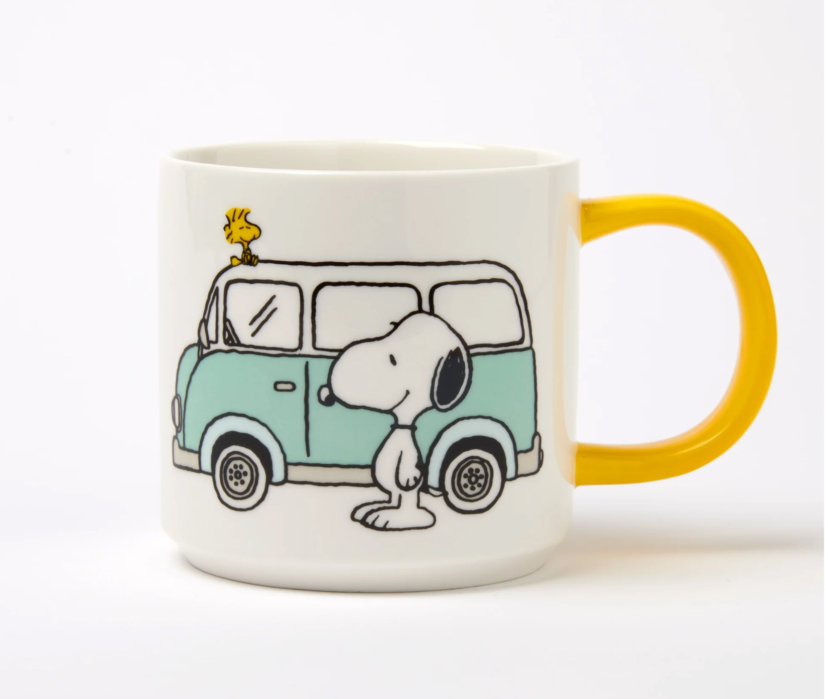 white mug with yellow handle. printed image of snoopy and woodstock with a blue camper van 
