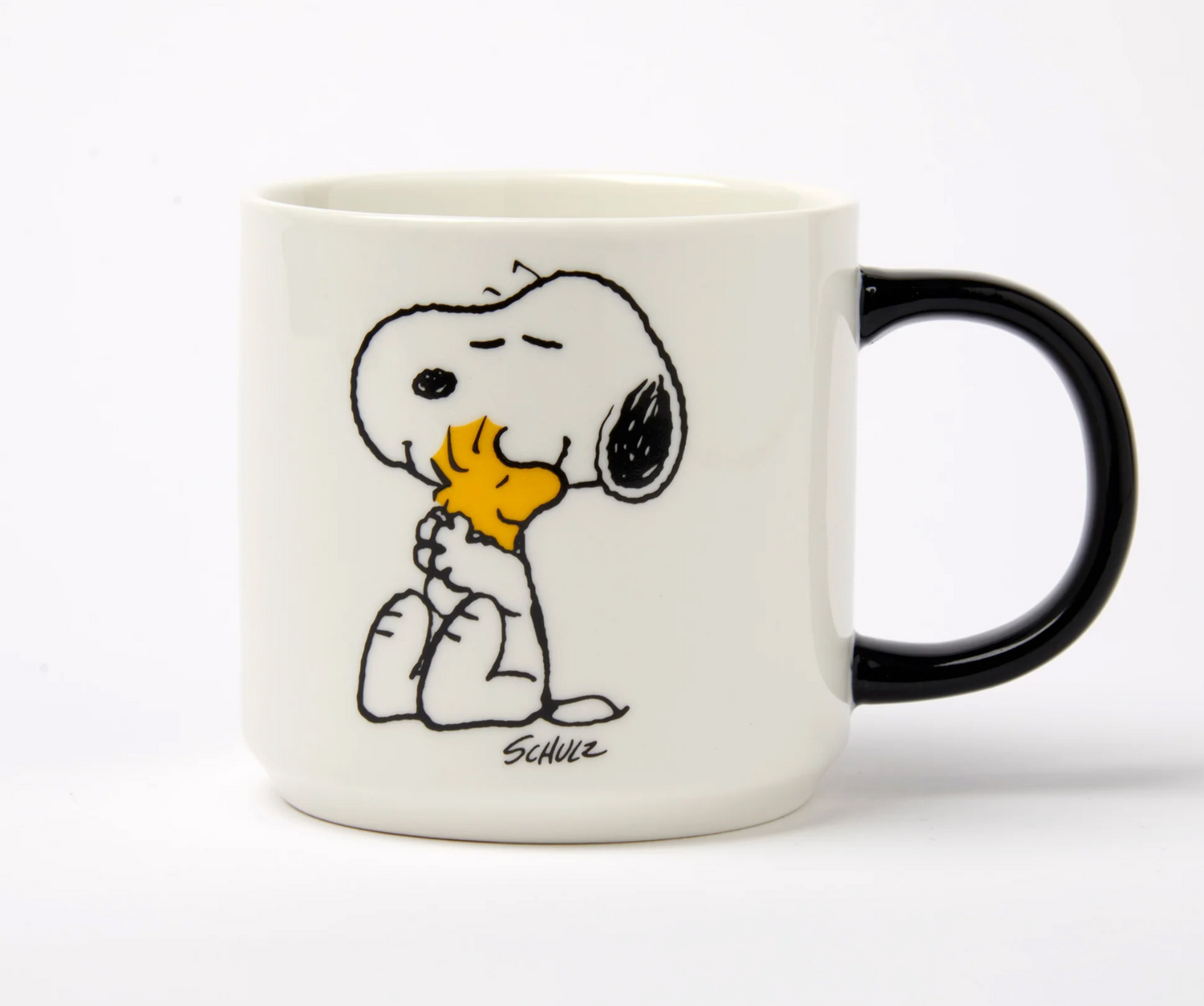 white mug with black handle. A cartoon snoopy and woodstock hugging 