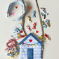 Wells Nest-the sea style Beach hut bag for Kids. white striped with colourful bunting and a red heart. surrounded by similar themed kids hair accesories on a white background 