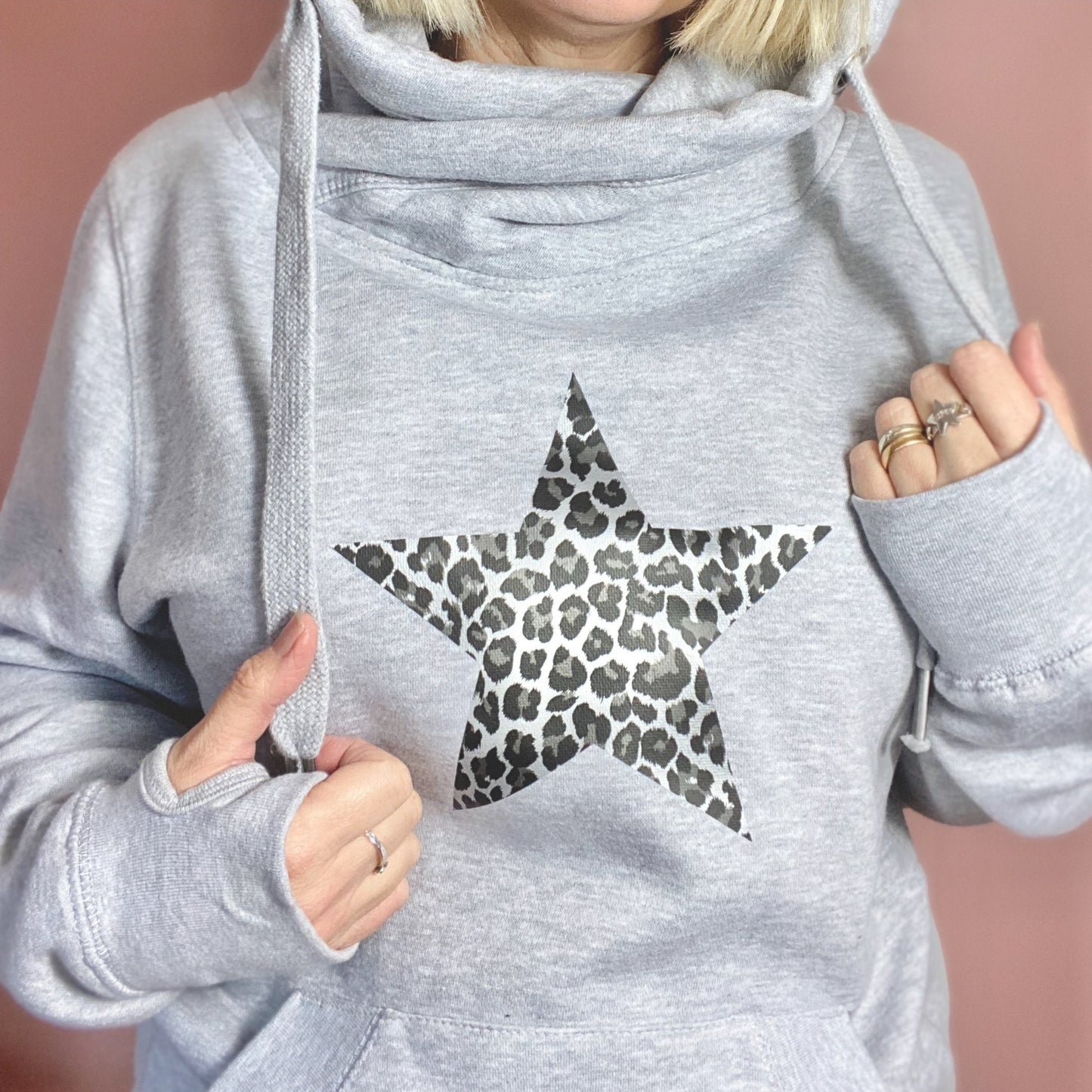 Shimmer & shine bright in our star leopard print cowl neck hoodie. They are super soft with a crossover cowl neck and chunky drawstrings. These heavyweight hoodies are great for weekend lounging or long dog walks on the beach.    The sweatshirt also has a pouch pocket with a small opening for an optional earphone cord feed & thumbholes in the sleeves to keep hands warm. Glitter & Mud 